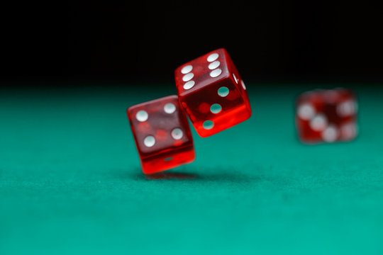 Photo of dice falling on green table