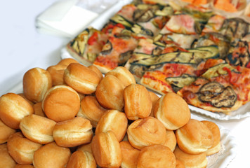 krapfen and pizza over the table during a buffet for the wedding