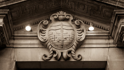 Bath Coat of Arms, English Crest of Bath, Plaque on Stone Wall, Vintage Keystone in Doorway, Architecture Detail in Sepia Tone low angle