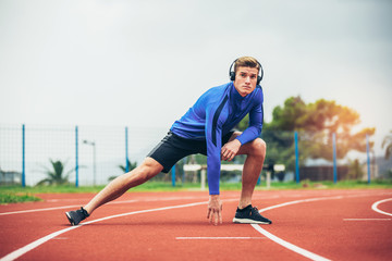 Obraz premium Young man is exercising on sunny day. He is stretching his body.