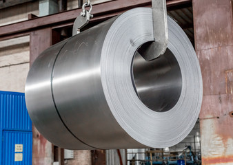 roll of sheet steel, transported by crane at the factory