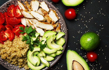 Healthy food, salad with avocado, quinoa, chicken and tomatoes on plate, top view