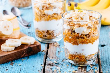 healthy breakfast parfait. homemade granola with natural yogurt, banana and caramel sauce