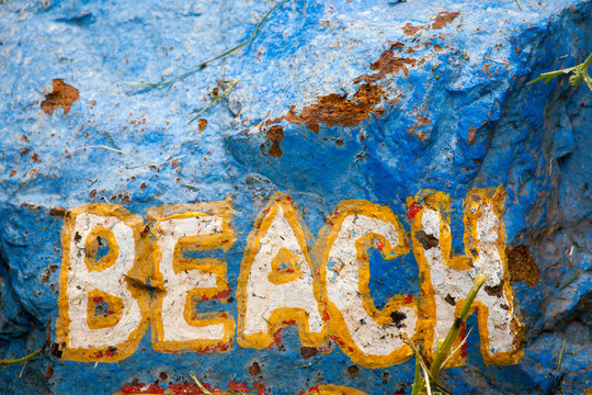 Colourful Beach Sign Painted On To A Rock
