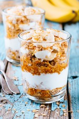 healthy breakfast parfait. homemade granola with natural yogurt, banana and caramel sauce
