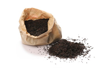 Black tea leaves in brown paper bag isolated on white background