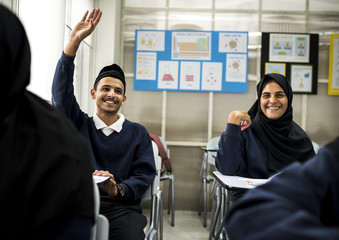 diverse muslim children studying in classroom