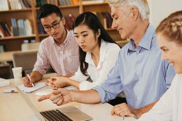 Experienced teacher giving extra lesson in library