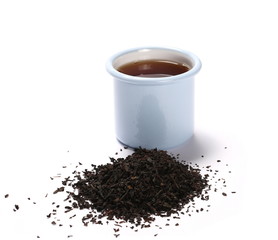 Black tea in blue metal cup and leaves isolated on white background