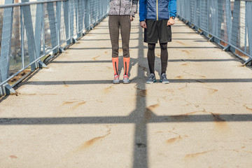 Runners Standing on Bridge