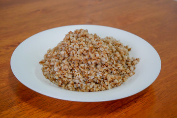 Buckwheat porridge in white plate. Healthy food.