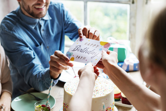 Man Giving Birthday Wishing Card To Friend