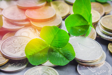 Scattered Russian coins on a gray background with leaves of clover. Good luck, St. Patrick's day.
