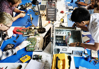 Electronics technicians team working on computer parts - obrazy, fototapety, plakaty