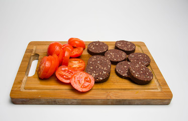 Black pudding and tomatoes on cutting board