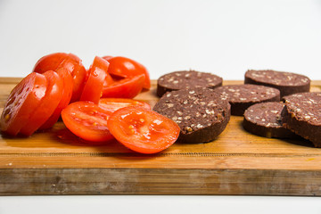 Black pudding and tomatoes on cutting board