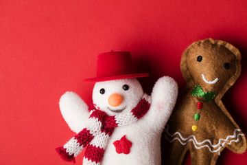 Festive snowman and gingerbread man decorations on a red background