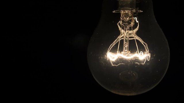 New idea collapses, fail concept. Light bulb burns out on black background