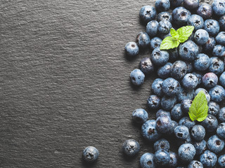 blueberries on gray slate background, top view, copy space