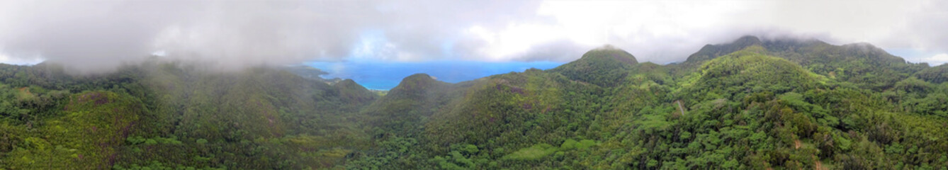 Fototapeta na wymiar Aerial panoramic view of beautiful tropical mountains shrouded by fog