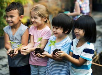 Group of diverse kids holding plants