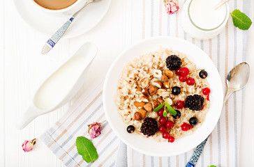 Tasty and healthy oatmeal porridge with berry, flax seeds and nuts. Healthy breakfast. Fitness food. Proper nutrition. Flat lay. Top view.