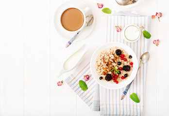 Tasty and healthy oatmeal porridge with berry, flax seeds and nuts. Healthy breakfast. Fitness food. Proper nutrition. Flat lay. Top view.