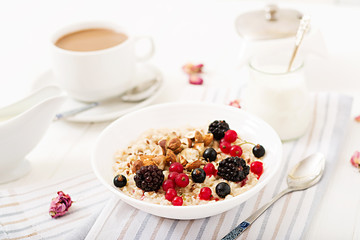 Tasty and healthy oatmeal porridge with berry, flax seeds and nuts. Healthy breakfast. Fitness food. Proper nutrition.