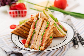 Club sandwich - panini with ham, cheese, tomato and herbs. Top view