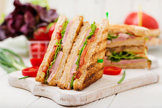 Club sandwich - panini with ham, cheese, tomato and herbs. Top view