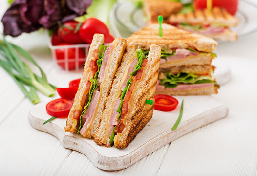 Club sandwich - panini with ham, cheese, tomato and herbs. Top view