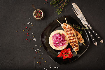 Fototapeta na wymiar Minced Lula kebab grilled turkey (chicken) with fresh tomato and bulgur. Flat lay. Top iew