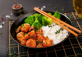 Pieces of chicken fillet with mushrooms stewed in tomato sauce with boiled broccoli and rice. Proper nutrition. Healthy lifestyle. Dietetic menu.