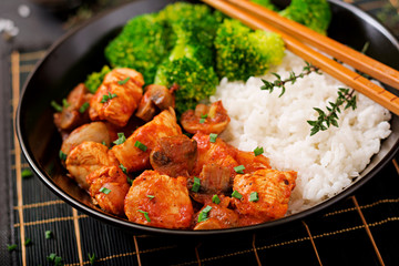 Pieces of chicken fillet with mushrooms stewed in tomato sauce with boiled broccoli and rice. Proper nutrition. Healthy lifestyle. Dietetic menu.