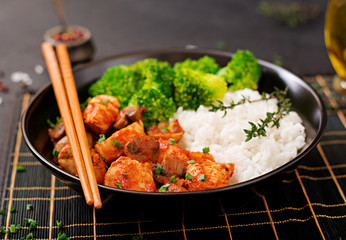Pieces of chicken fillet with mushrooms stewed in tomato sauce with boiled broccoli and rice. Proper nutrition. Healthy lifestyle. Dietetic menu.