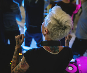 Dj playing music at sound mixer in night club