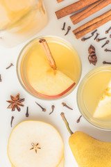 top view of glasses of cider with spices on white surface