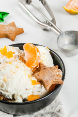 Winter Ice cream with gingerbread and tangerines, on white marble background, copy space