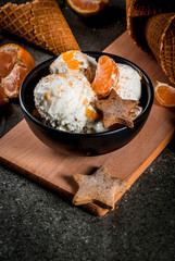 Winter Ice cream with gingerbread and tangerines, on black stone background, copy space