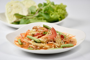 Traditional thai cuisine spicy green papaya salad on white background