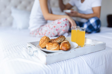 Young attractive couple having breakfast in bed