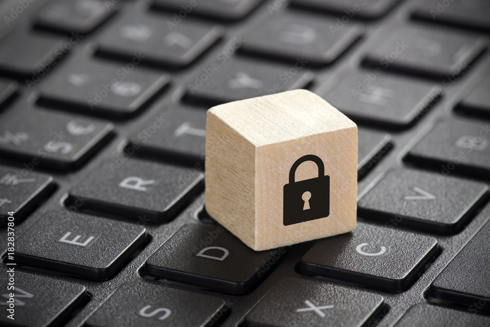 Poster wooden block with lock graphic on laptop keyboard. computer security concept.