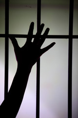 silhouette of hand in jail