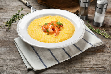 Plate with fresh tasty shrimp and grits on wooden table
