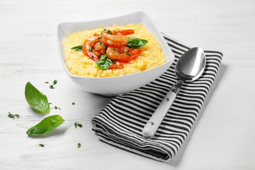 Bowl with fresh tasty shrimp and grits on white wooden table
