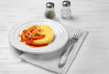 Plate with fresh tasty shrimp and grits on white wooden table