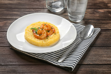 Plate with fresh tasty shrimp and grits on wooden table