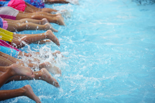 legshot of children at swimming pool class learning to swim