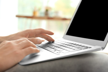 Man using laptop indoors, closeup