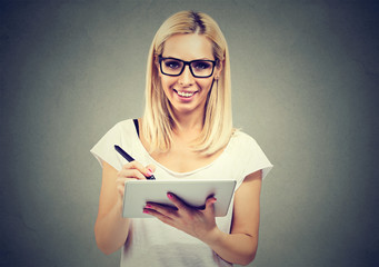 Closeup portrait of a cheerful woman working with stylus and digital tablet pc
